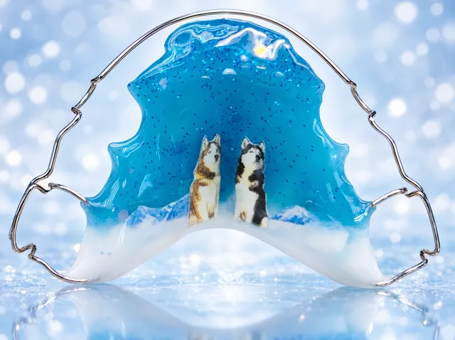 Snow panorama with a turquoise sky, blue glitter and huskies